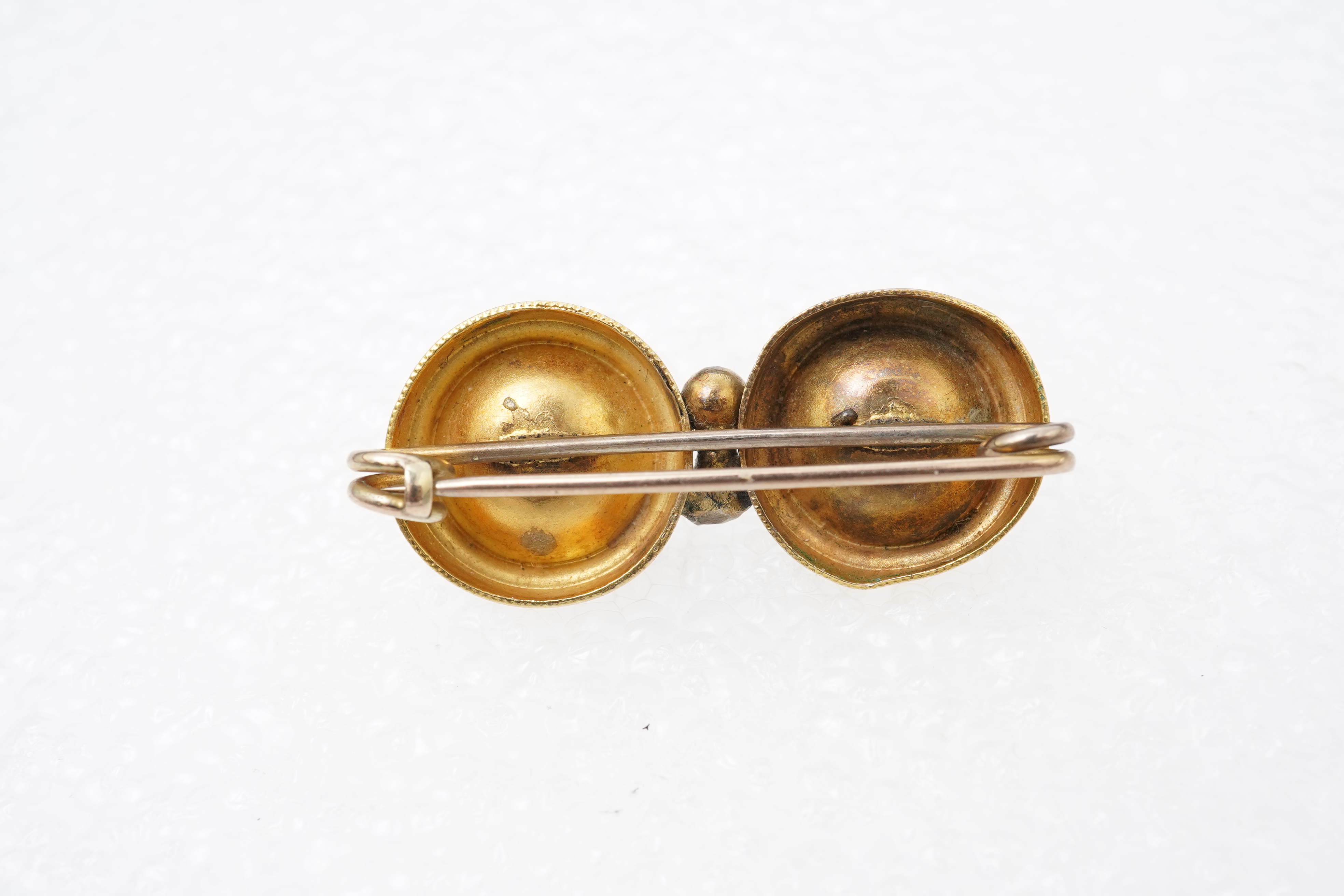 A Victorian ruby and gold double target brooch, late 19th century and later, composed of two roundels set with circular-cut garnets, with wirework details, length 3.7cm, gross weight approximately 3.5 grams